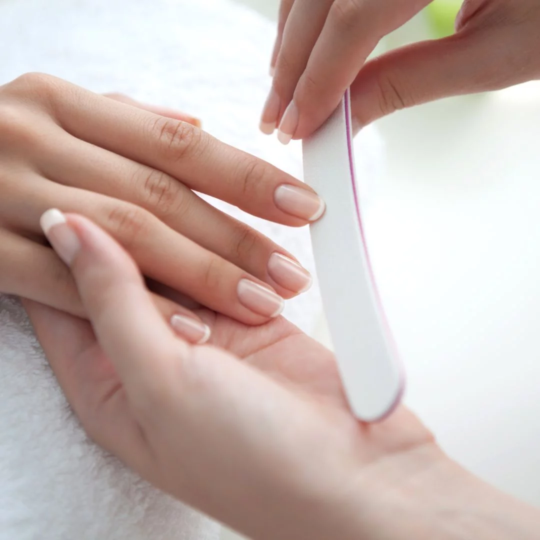 Nahaufnahme einer professionellen Maniküre-Behandlung mit einer Nagelfeile.